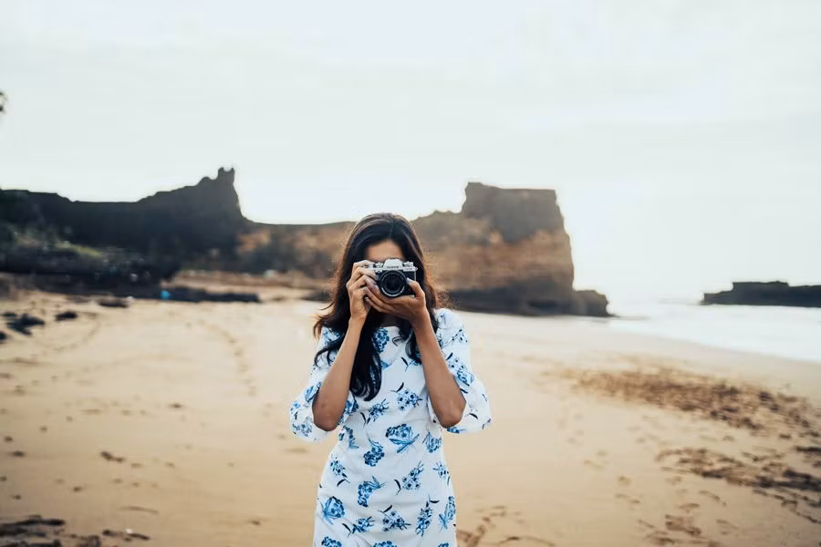 mujer haciendo una foto en una playa